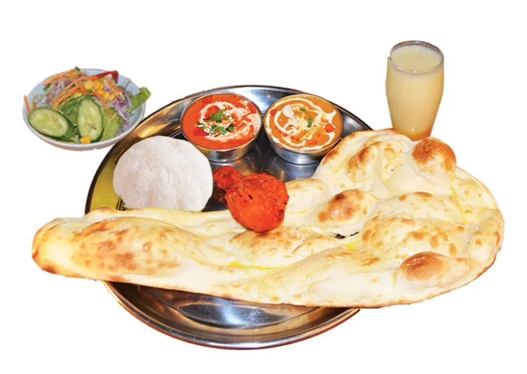 ナン、カレー、ライス、サラダなどが並ぶインド料理のセット